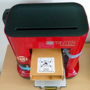 Zunächst müssen Kartons und blaue Schleifen vom XYZprinting Drucker entfernt werden Zunächst müssen Kartons und blaue Schleifen vom XYZprinting Drucker entfernt werden