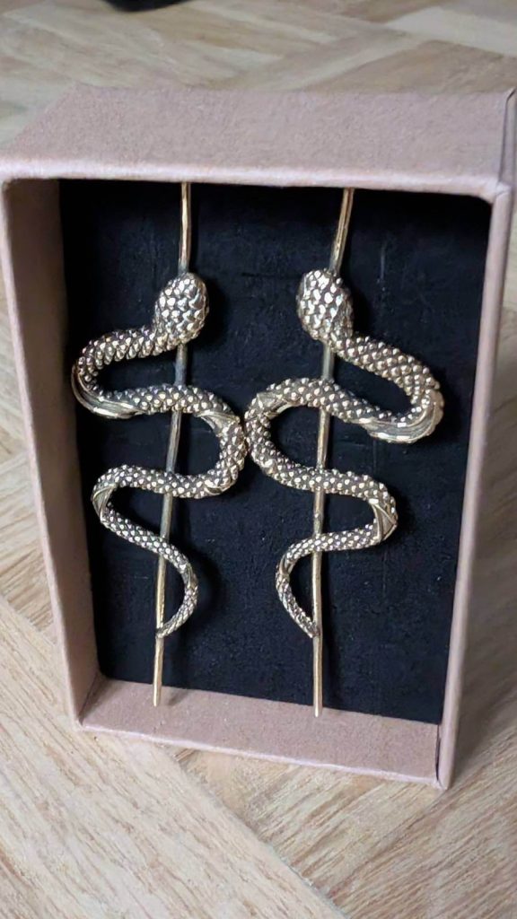 Vergoldet, aber passend zur Schlangenhaut eher matt.